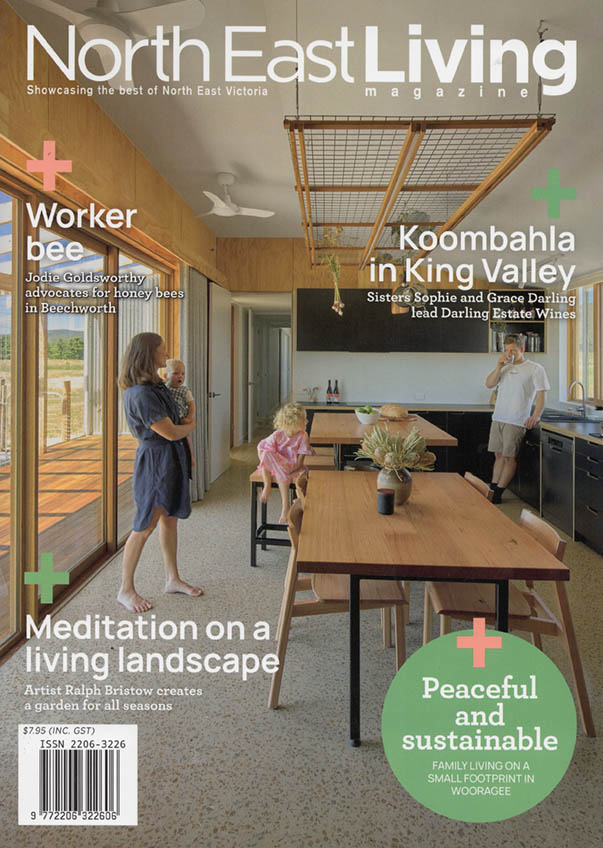 Cover of NorthEast Living shows a couple ing a new home with a wooden tables and a mother and child on the left